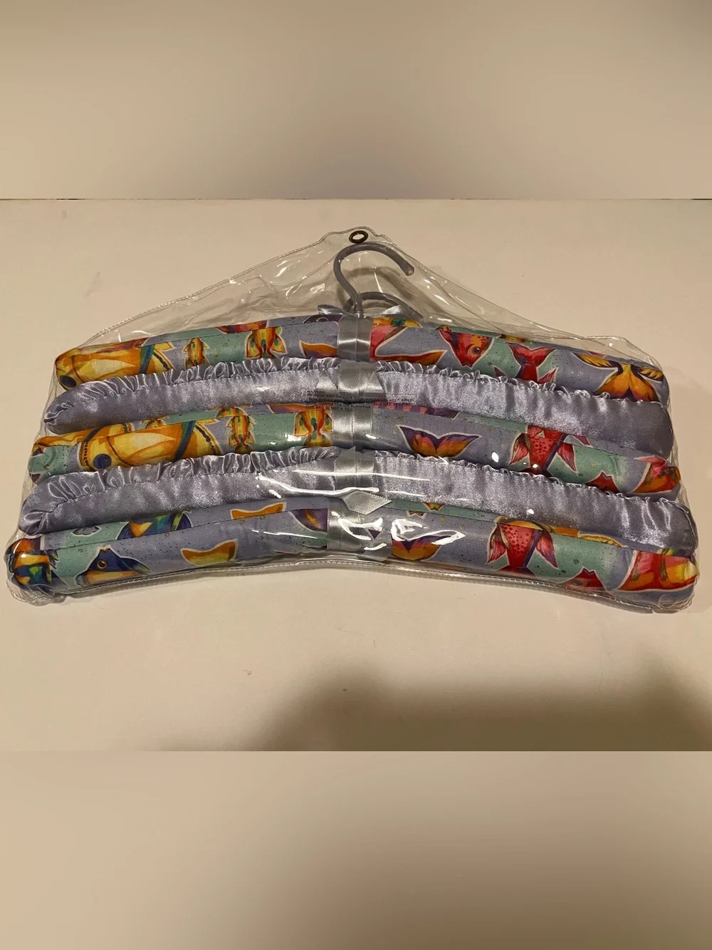 NWOT LOT OF COLORFUL PADDED FISH HANGERS.